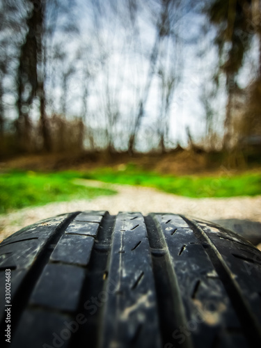 close up of a car tire in front of a park with a nice depth of field