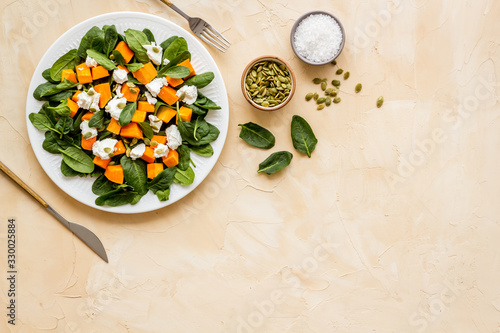 Healthy food concept. Salad with pumpkin and basil on beige background top-down copy space © 9dreamstudio
