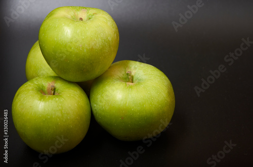 Three fresh green apples isolated on black background