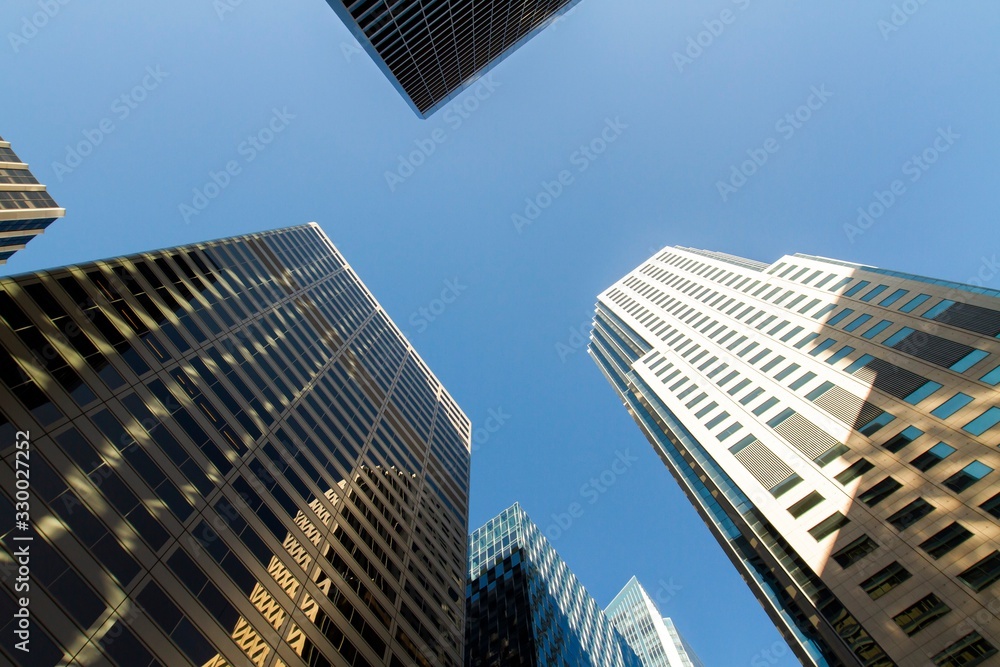 Bottom view of modern office buildings in financial district at sunset, real estate and success concept, USA Bottom view of modern office buildings in financial district at sunset, real estate and success concept, USA