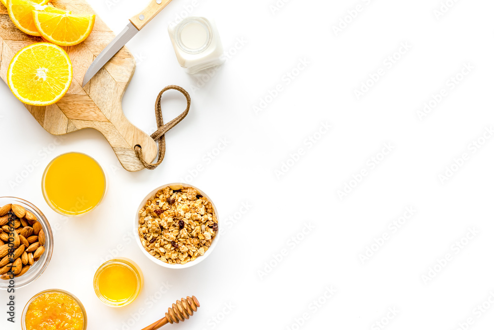 Morning granola near toast and oranges on white background top-down frame copy space Morning granola near toast and oranges on white background top-down frame copy space