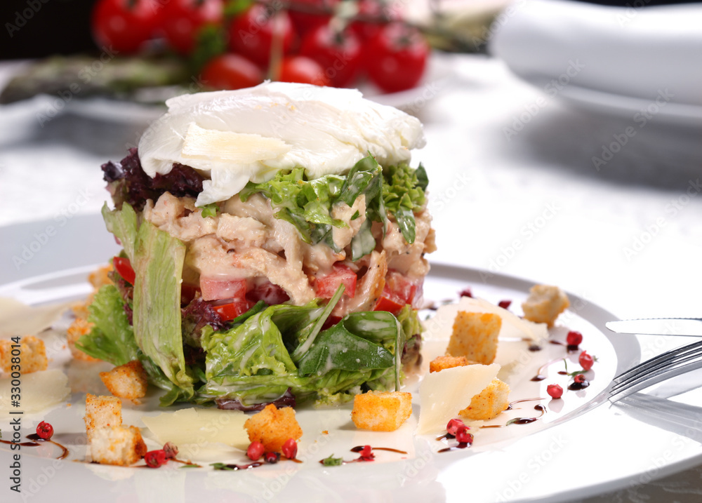Gourmet warm salad with chicken, vegetables and mozzarella with crackers on a white plate in a restaurant. Gourmet warm salad with chicken, vegetables and mozzarella with crackers on a white plate in a restaurant.