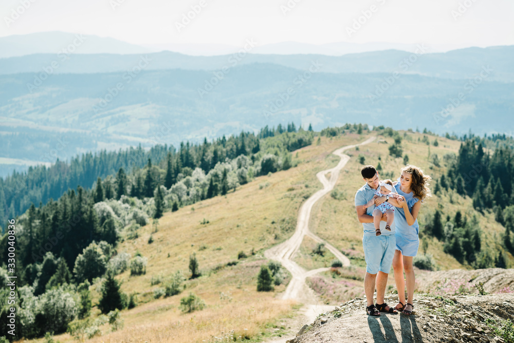 Portrait of happy family. Mom, dad hugging daughter at nature. Young couple spending time together on vacation, outdoors. The concept of summer holiday. Mother's, father's, baby's day.