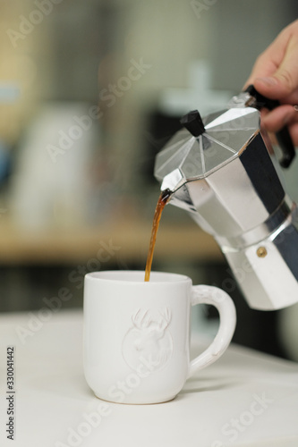 Breakfast in the cafe. The process of pouring coffee from a geyser coffee maker into a mug. 