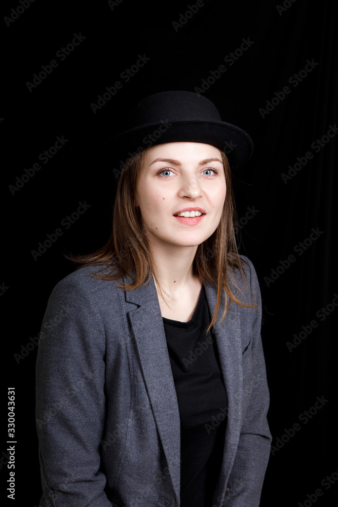 cute young girl in hat and gray jacket on black background cute young girl in hat and gray jacket on black background