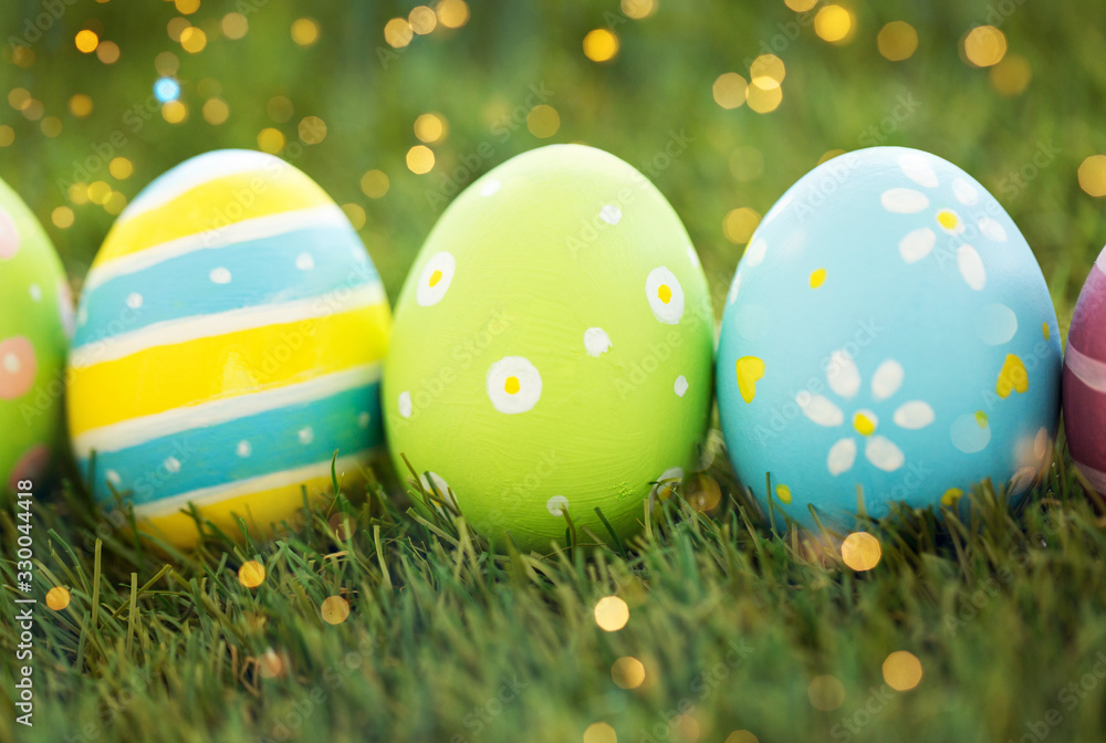easter, holidays and tradition concept - row of colored eggs on artificial grass easter, holidays and tradition concept - row of colored eggs on artificial grass