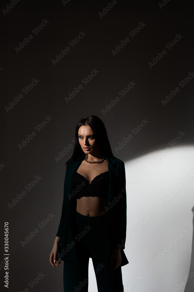 Studio photo of pretty brunette woman in twilight in bra looks into the distance Studio photo of pretty brunette woman in twilight in bra looks into the distance