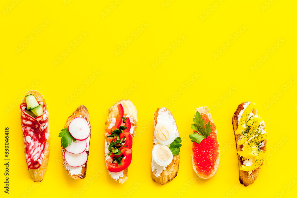 Sandwiches assorti pattern on yellow background top-down copy space