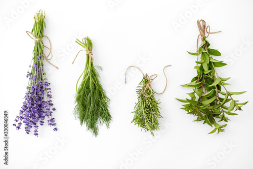 gardening, ethnoscience and organic concept - bunches of greens, spices or medicinal herbs on white background
