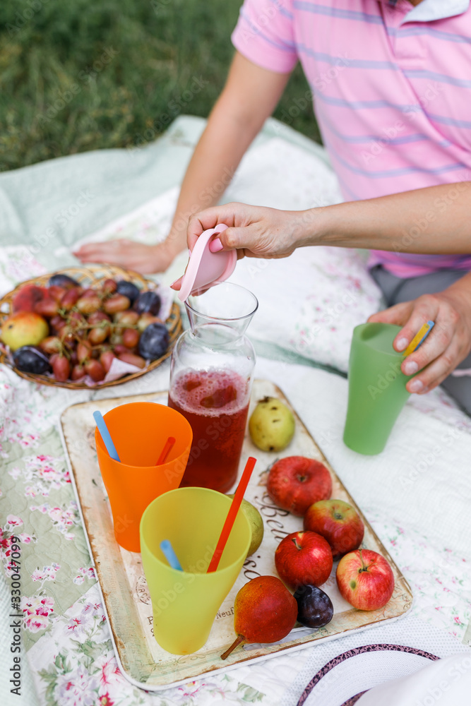 people on a picnic pour fresh in glasses on a bedspread with fruit on nature people on a picnic pour fresh in glasses on a bedspread with fruit on nature