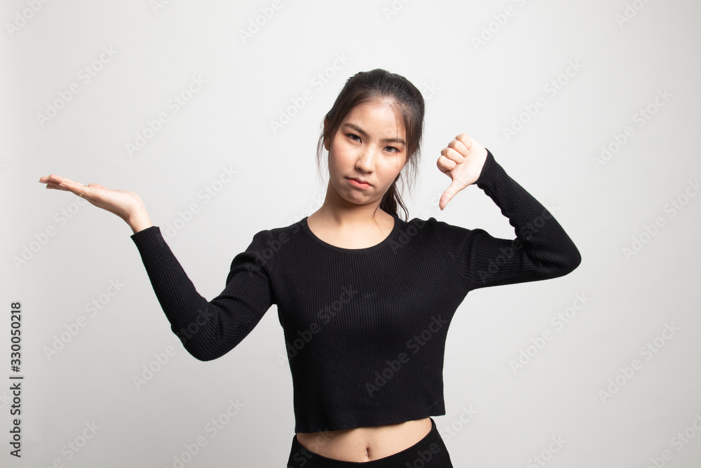 Young Asian woman show palm hand and thumbs down. Young Asian woman show palm hand and thumbs down.