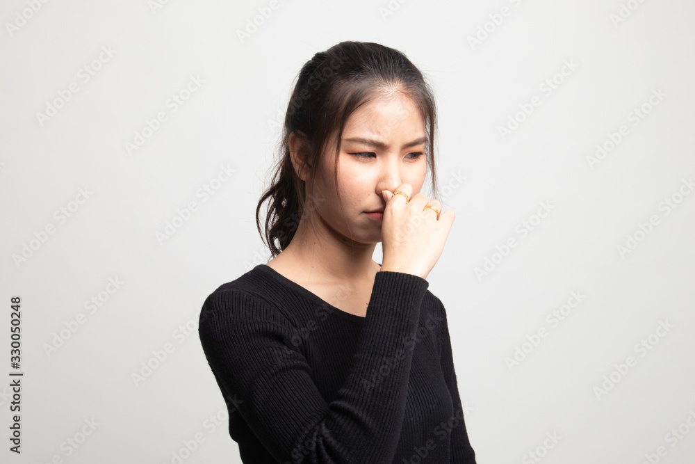 Young Asian woman holding her nose because of a bad smell. Young Asian woman holding her nose because of a bad smell.