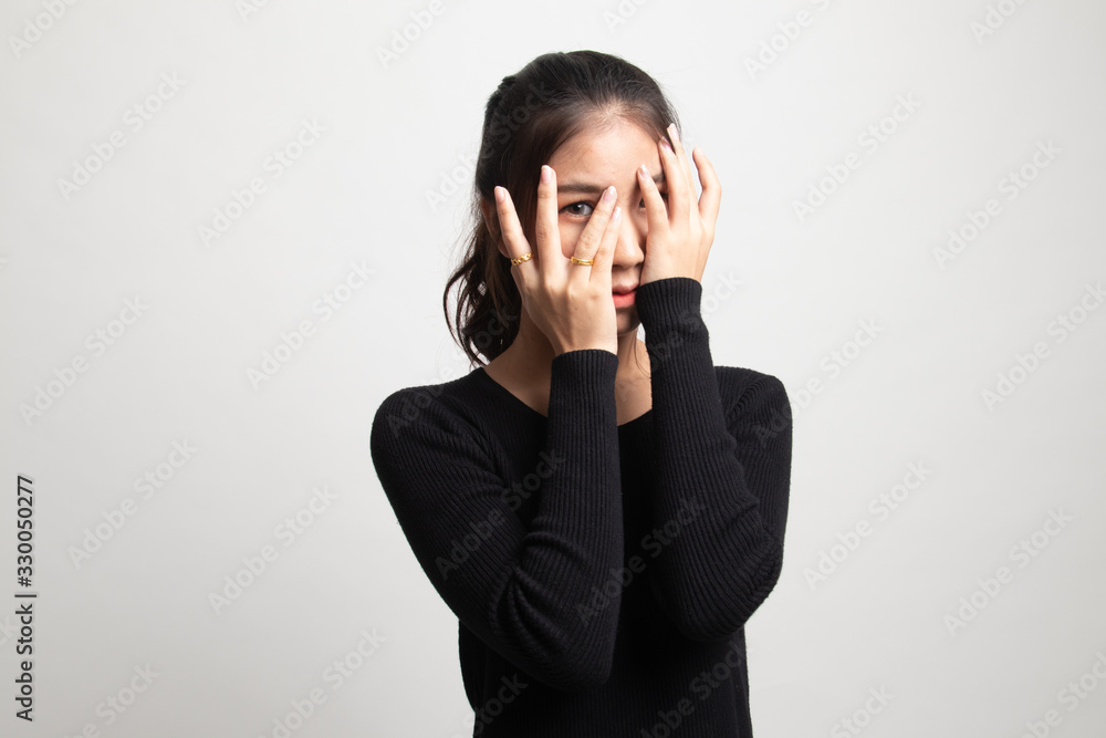 Beautiful young Asian woman peeking through fingers. Beautiful young Asian woman peeking through fingers.