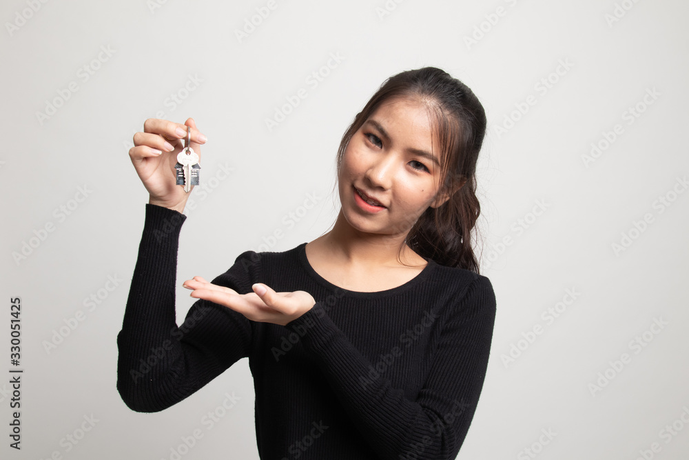 Cute asian girl showing home residence keys. Cute asian girl showing home residence keys.
