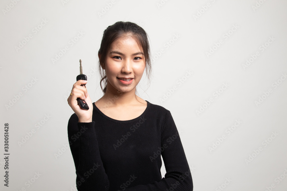 Cute asian girl showing home residence keys. Cute asian girl showing home residence keys.