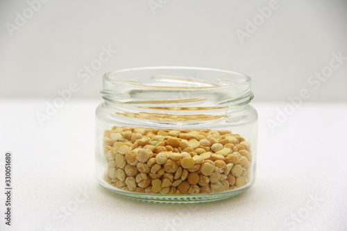 Glass jar with groats on a white background, side view.