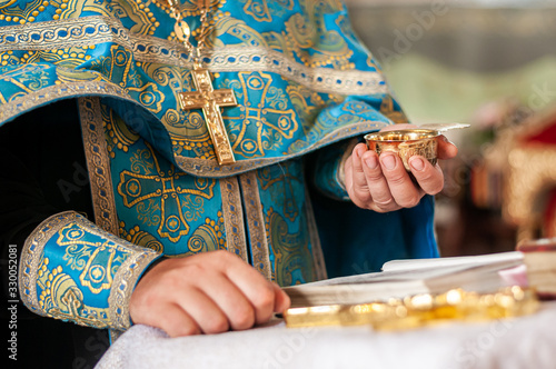 Принти на полотні Priest holding silver chalice with wine