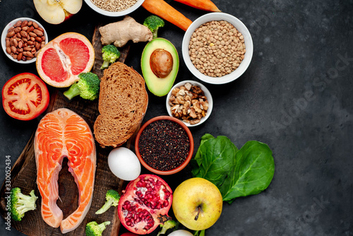 Selection of healthy food  salmon  fruits  seeds  cereals  superfoods  vegetables  leafy vegetables on a stone background   with copy space for your text.Healthy food for people 