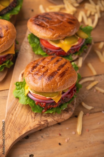 burgers, fast food. Calorie and tasty food. On a wooden background, vertical photo