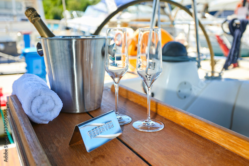 Romantic luxury evening on cruise yacht with champagne setting. Empty glasses and bottle with champagne and tropical sunset with sea background © fox17