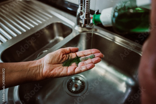 Middle-aged woman washing her hands with soap and water to avoid contagion of the coronavirus. Health risk prevention in old population. Healthcare