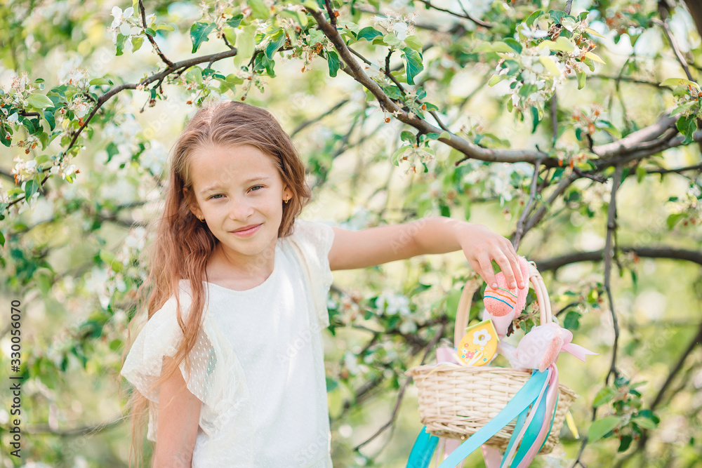 Adorable little girl in blooming apple garden on beautiful spring day Adorable little girl in blooming apple garden on beautiful spring day