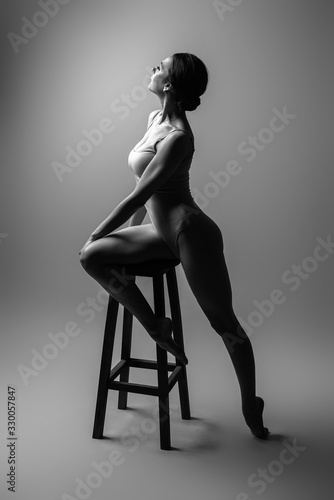 Sexy gymnast woman sitting on the chair