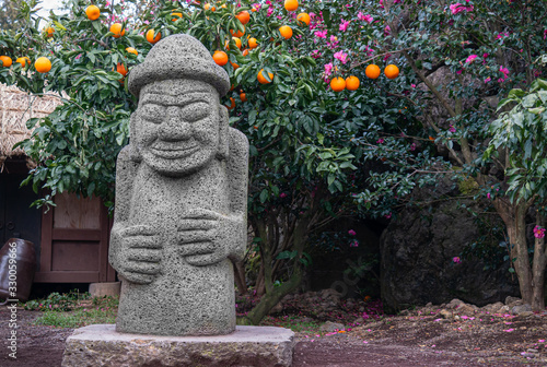 A landscape with mandarin orange and Dol Harubang made of basalt, a symbol of Jeju Island.