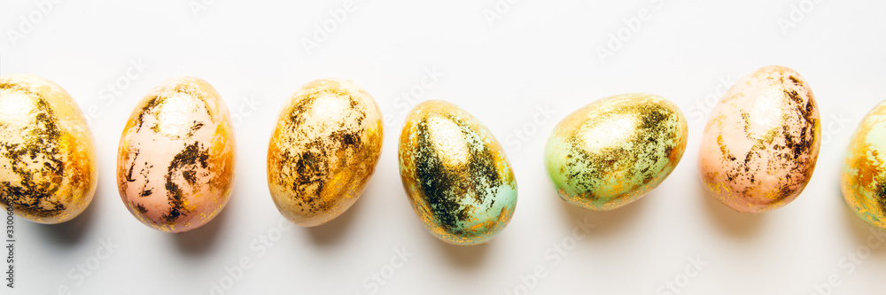 Natural Golden Speckled Easter Eggs of pastel colors on white background. Happy Easter card concept, minimalistic design, copy space, banner size Natural Golden Speckled Easter Eggs of pastel colors on white background. Happy Easter card concept, minimalistic design, copy space, banner size