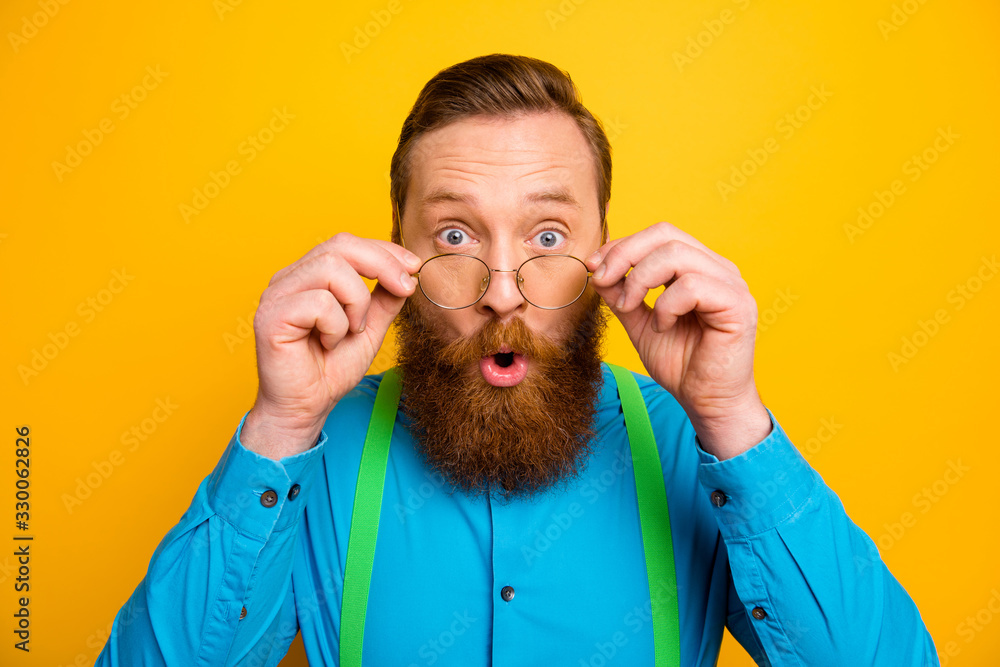 Closeup photo of attractive red head guy taking off specs excited good eyesight after correction operation wear bright blue shirt green suspenders isolated yellow color background - obrazy, fototapety, plakaty 