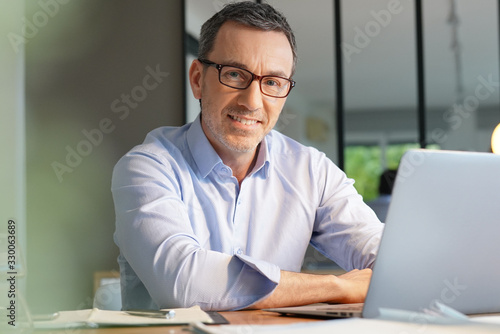 Business manager working in office on laptop photo