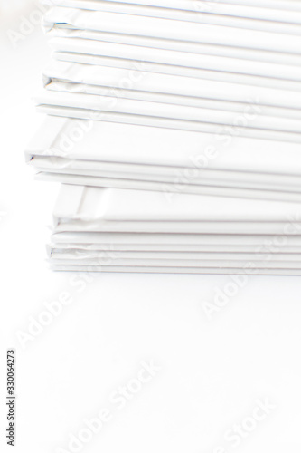 Stack of white books in geometric placement on white background. White abstract background. Copy space.