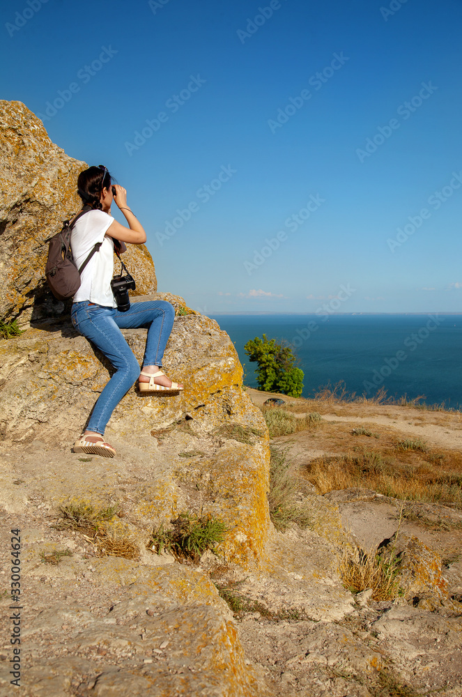 Naklejka premium Thin girl with camera in nature, by the sea