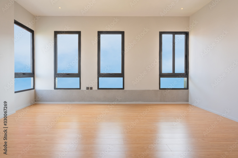 Obraz premium Empty room interior with windows overlooking the blue sky, Beautiful wooden floor and white wall modern architecture