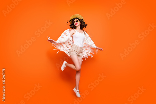 Full length photo of funny lady summer time jumping high enjoy great resort views wear stylish sun hat specs stylish white lace beach cape shorts isolated orange background