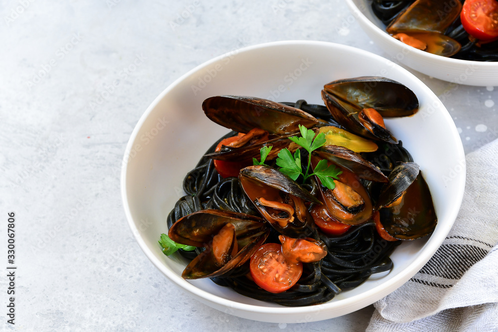 Black spaghetti. Black seafood pasta with mussels. Mediterranean delicacy food. black pasta with cuttlefish ink, recipe Italian food, spanish food. selective focus and copy space Black spaghetti. Black seafood pasta with mussels. Mediterranean delicacy food. black pasta with cuttlefish ink, recipe Italian food, spanish food. selective focus and copy space