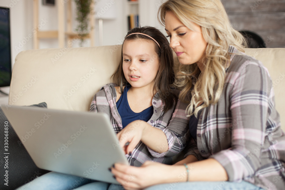 Mother and daughter using laptop with wireless technology Mother and daughter using laptop with wireless technology