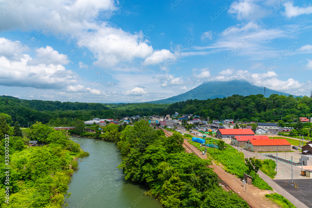 Townscape of Niseko in springtime sunny day with Mount Yotei in the background. A town located in Shiribeshi Subprefecture. Hokkaido, Japan