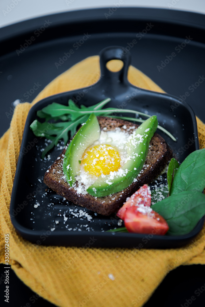 Avocado sandwich with fried egg. Egg on toasted bread for healthy