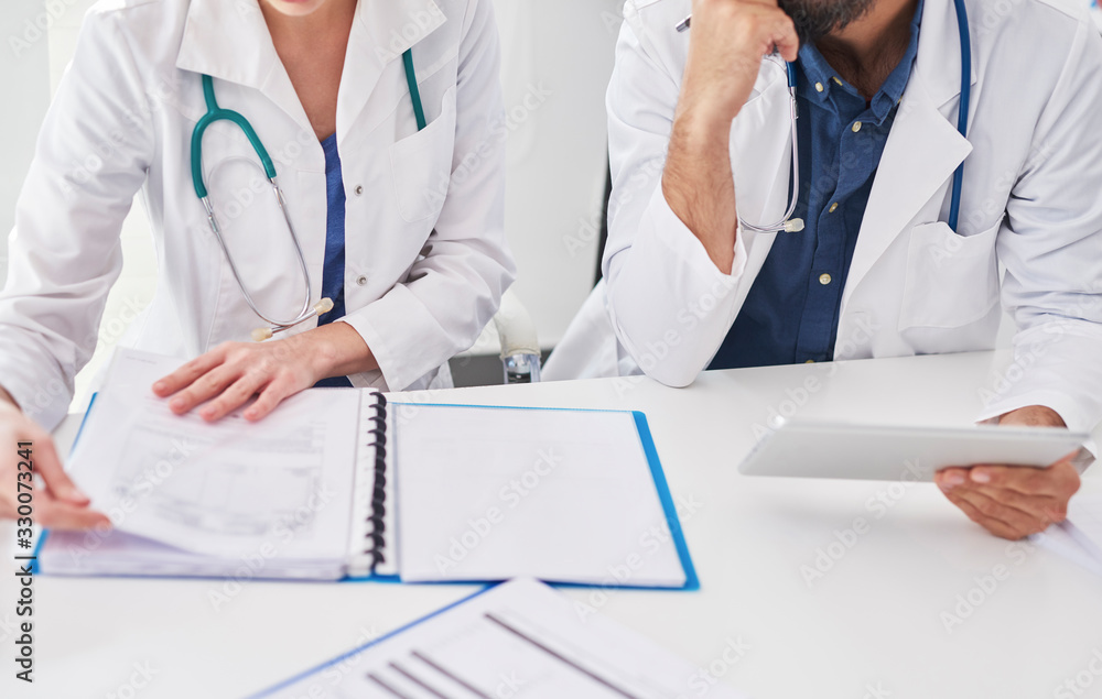 Two busy doctors checking medical results Two busy doctors checking medical results
