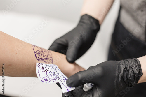 A tattoo artist revealing the design of the dog tattoo on a woman