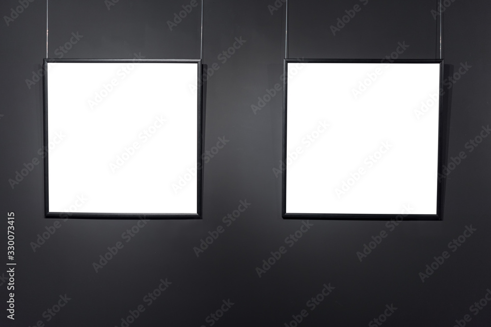 Empty square frames on black brick wall. Blank space posters or art frame waiting to be filled. Square Black Frame Mock-Up
