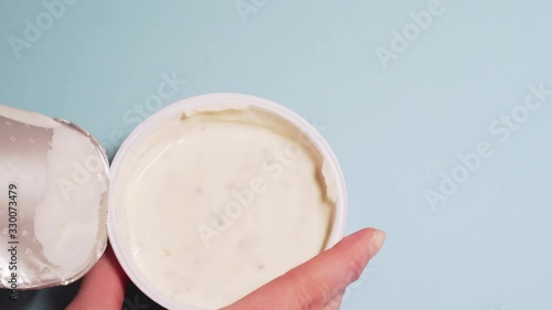 Eco-friendly curd cream with in coconut milk. Female hands tear off the lid from a jar of curd cream. Copyspace for your text