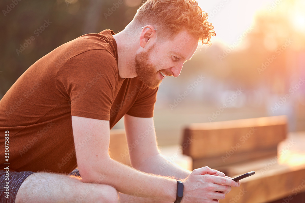 Obraz premium Man using cellphone in urban area at summertime.