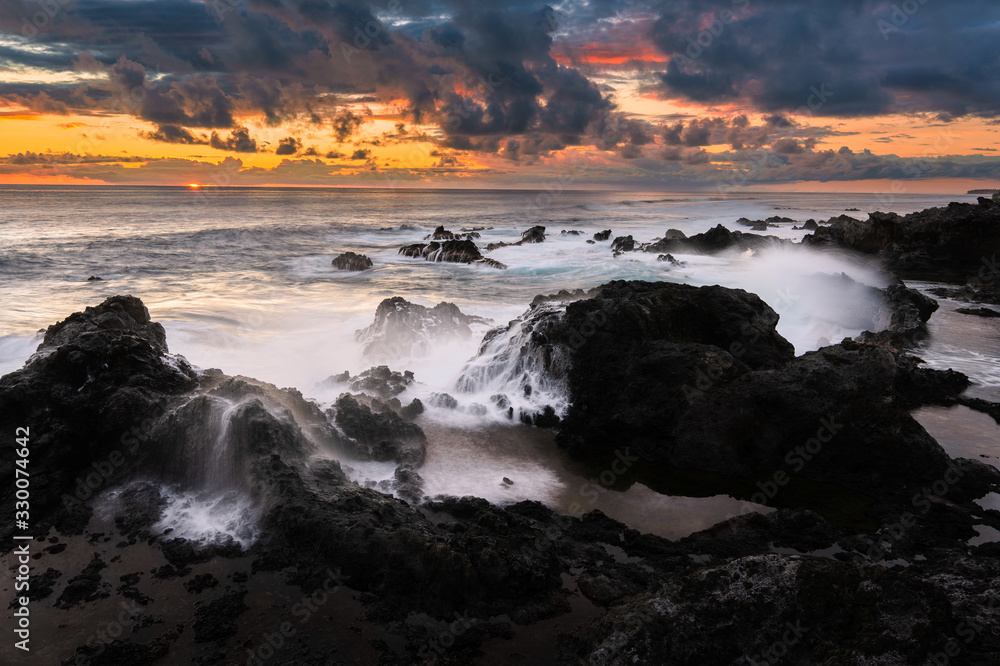 coucher de soleil sur la côte de l'océan indien, vagues déferlant sur les rochers
