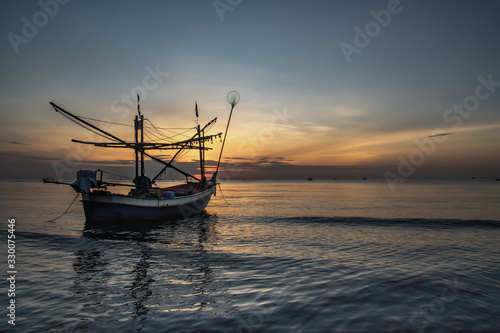 Thai fishing boat used as a vehicle for finding fish in the during beautiful twilight in the sea.