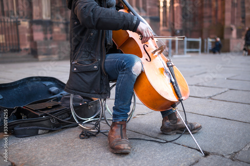 Street poor musician selflessly and masterfully plays the cello