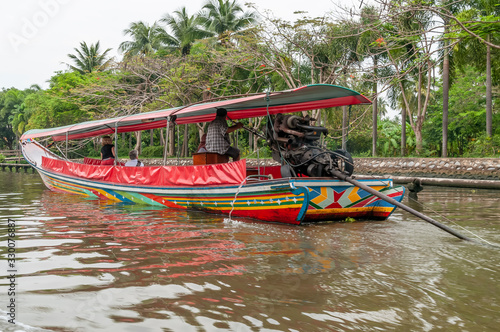 Canvas Print Colorful long tail boat sails in a canal in the center of Bangkok, Thailand, to