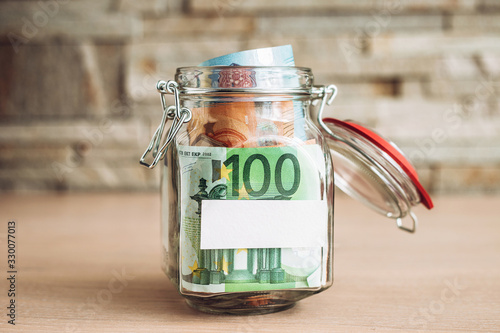 Obraz na plátně Banknotes of Euro in a glass jar and a place for signature - copyspace - piggy b