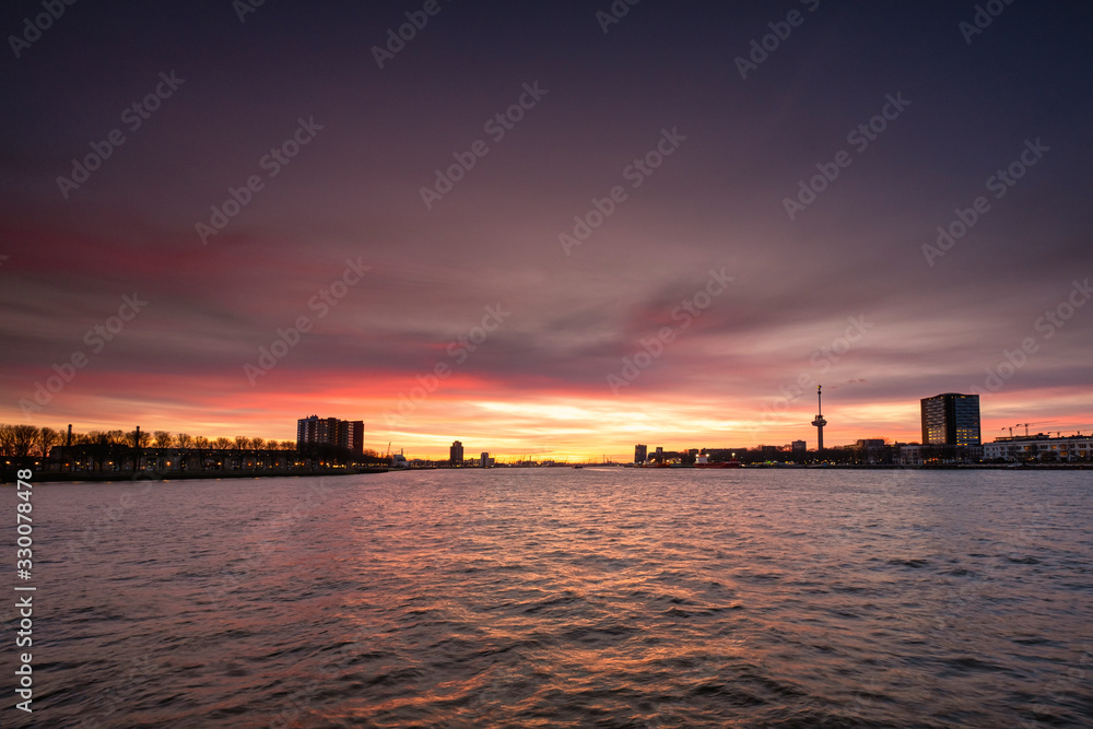 The skyline of Rotterdam at night. Maas canal on the foreground, sunset with nice sky, Rotterdam, THe Netherlands